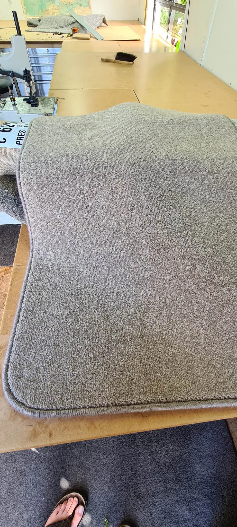 Beige carpet with finished overlocked edges on workshop bench