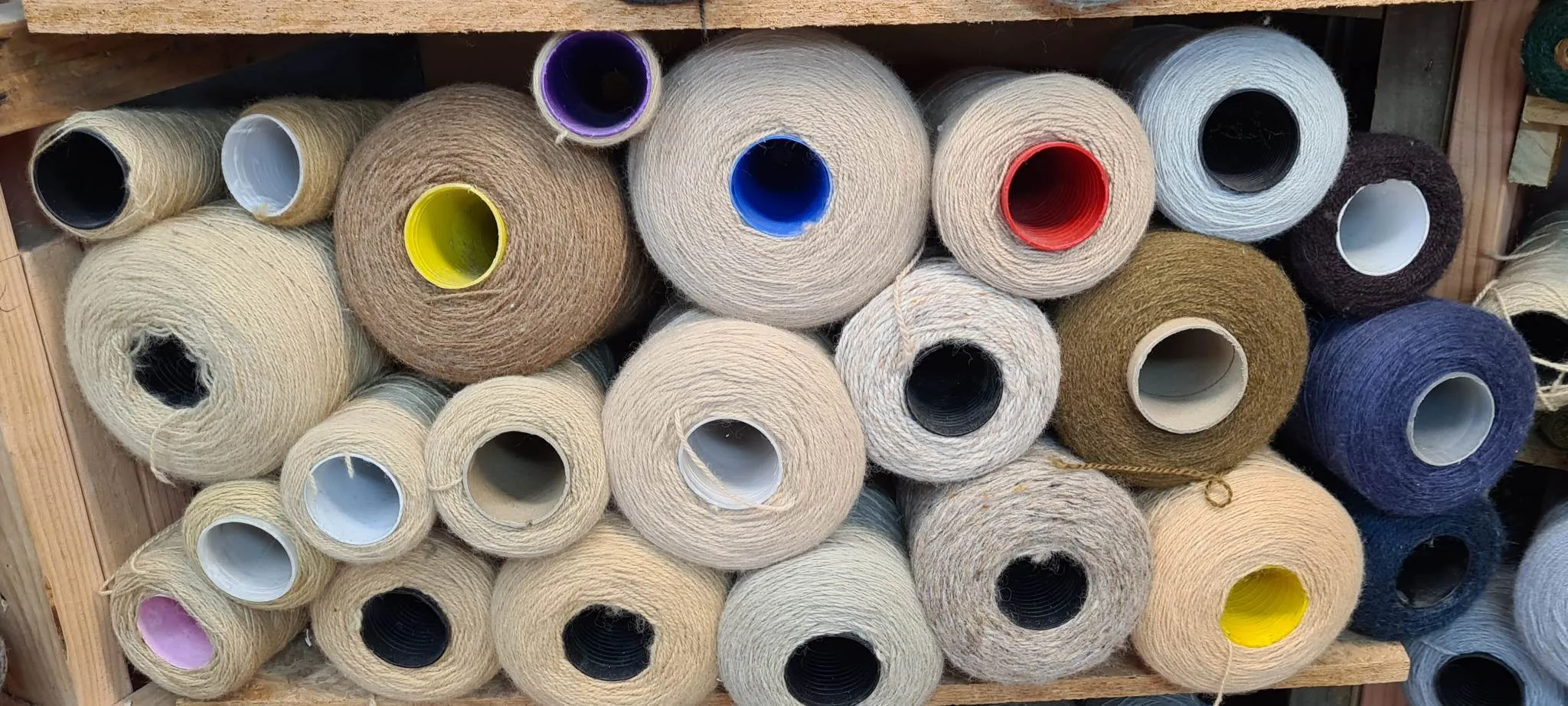 Industrial yarn spools in neutral colours for carpet edging