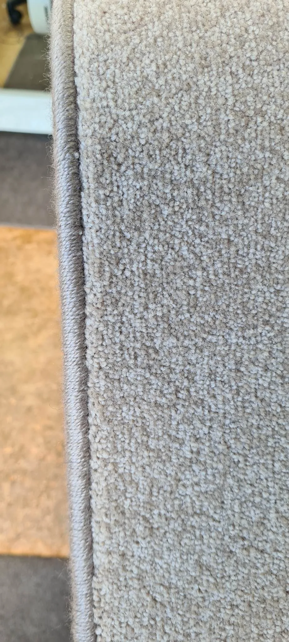 Detail of professional overlocked edge on beige carpet